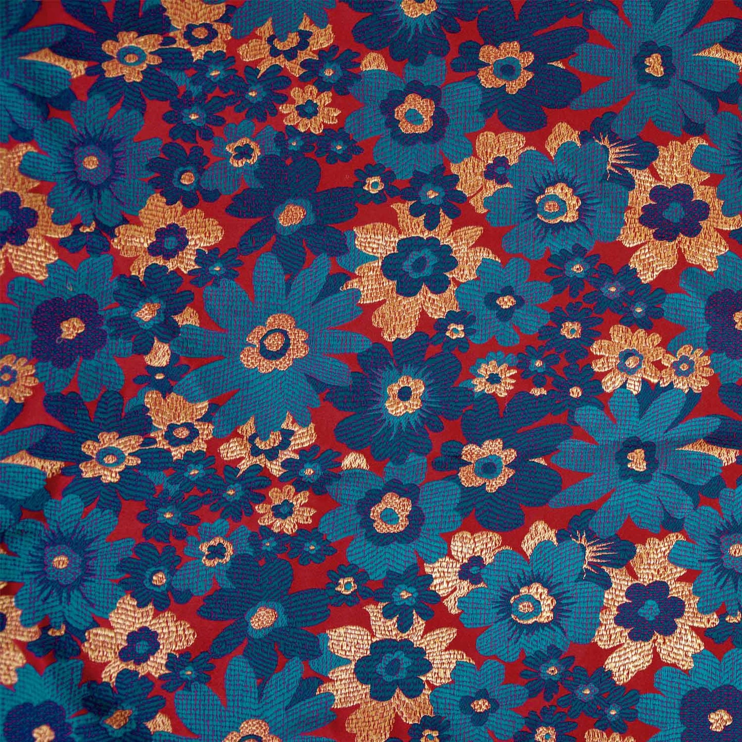 Brokaat stof met bloemenprint in de kleuren rood blauw en geel.