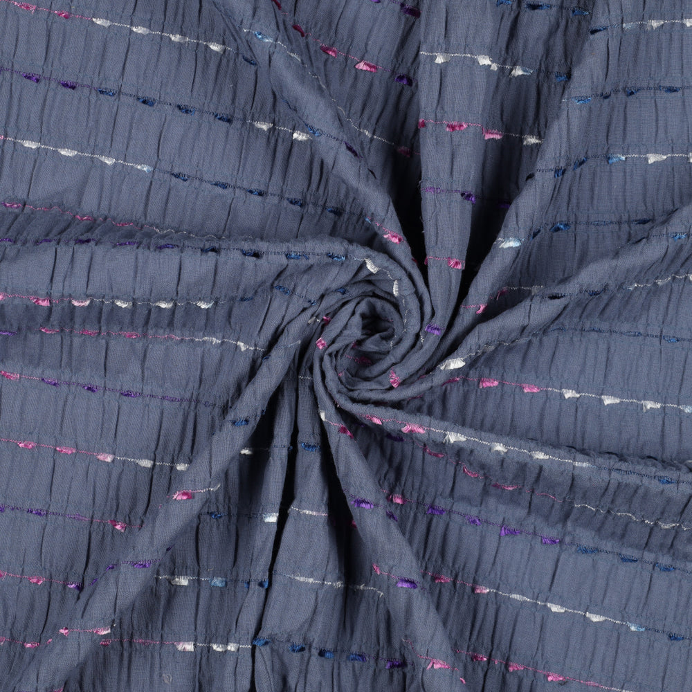 Jeansblauwe crinkel katoen met geborduurde gekleurde streepjes.