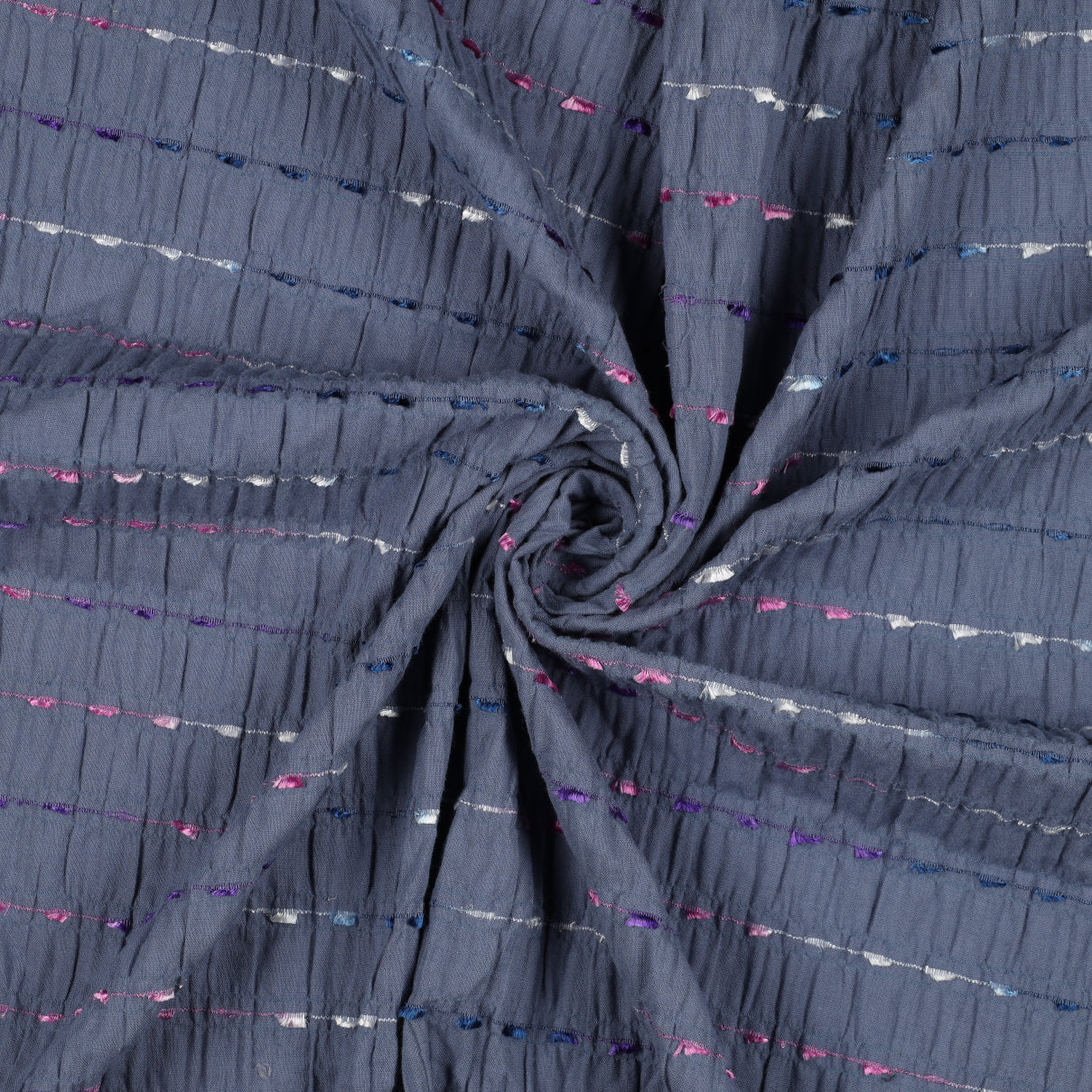 Jeansblauwe crinkel katoen met geborduurde gekleurde streepjes.