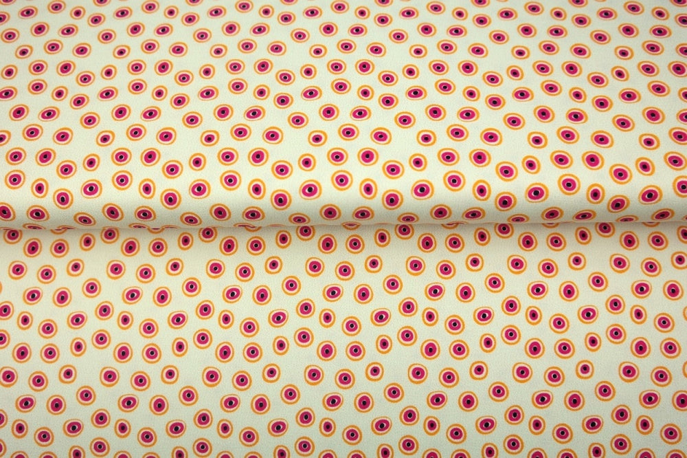 Creme kleurige digitale print jersey met oranje roze rondjes, oogjes.