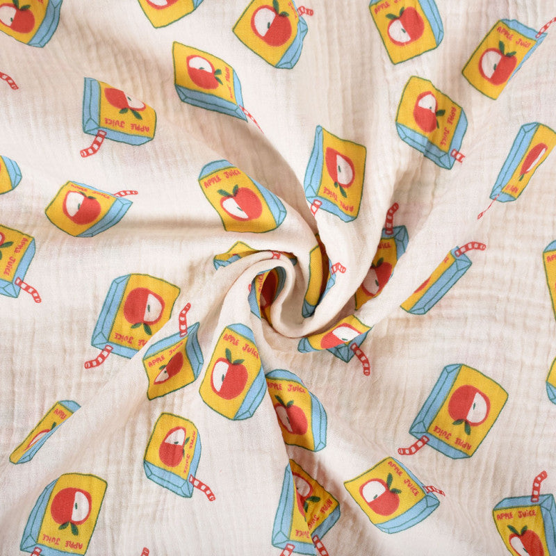 Ecru kleurige double gauze met pakjes appelsap als afbeelding, voor het maken van bijvoorbeeld babykleding of een slaapzak.