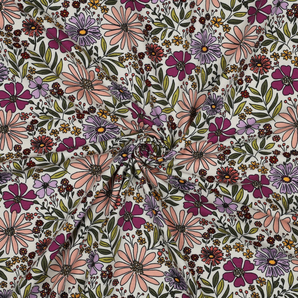 Offwhite tricot met bloemen in kleuren zoals lila, zalm en paars.