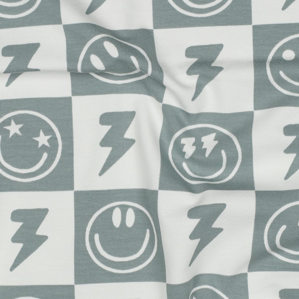 
                  
                    Saliegroen met gebroken witte jersey met smiley en bliksem in blokjes voor bijvoorbeeld een shirt voor jongens.
                  
                