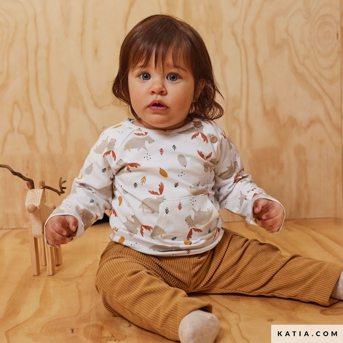 Baby truitje gemaakt van witte jersey met rendieren erop.