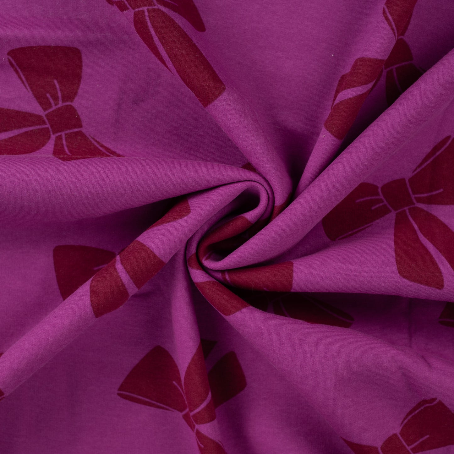 Joggingsstof in de kleur fuchsia met strikken.