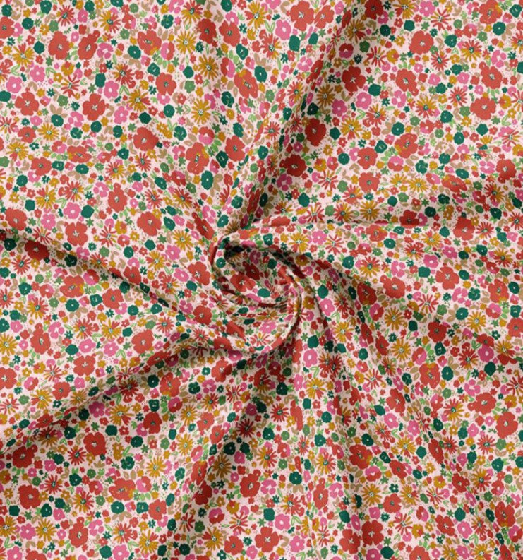 Katoenen stof met zomerse bloemetjes in roze rood groen en geel.