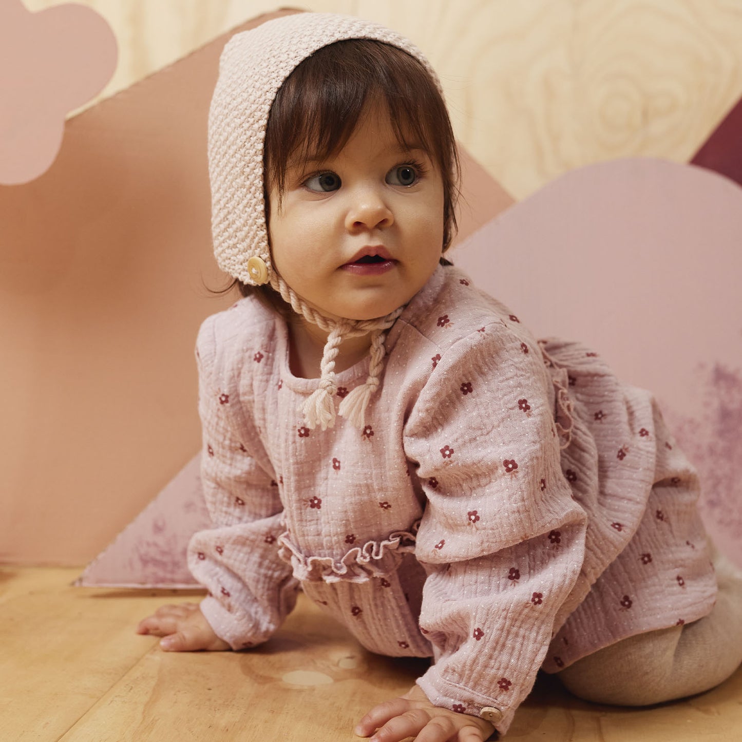 Babypakje gemaakt van oudroze hydrofiel met witte stipjes en bloemetjes.