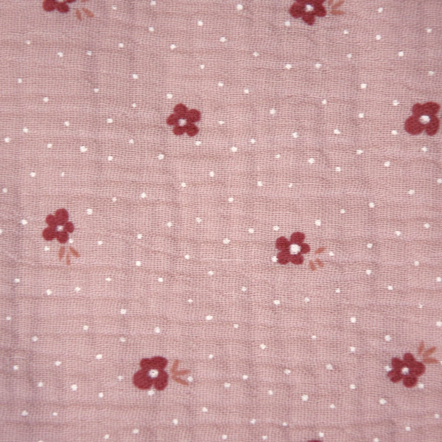 Oudroze double gauze stof met witte stipjes en donker roze bloemetjes.