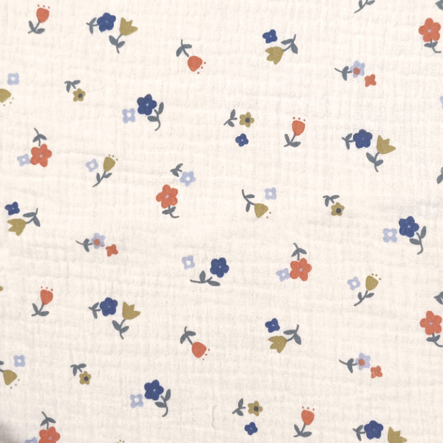 Ecru kleurige double gauze met kleine blauwe groen en rode bloemetjes.