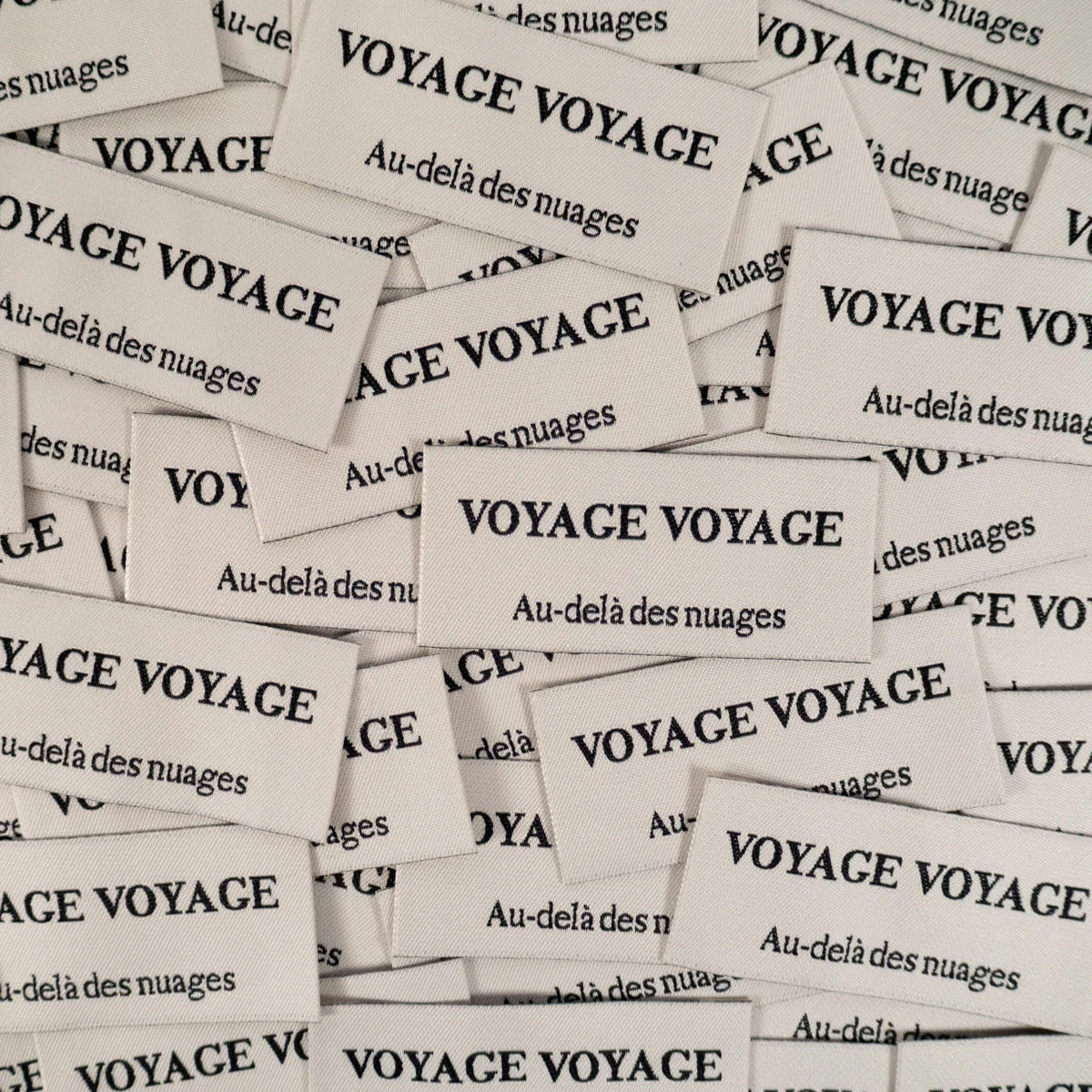 Geweven labels met tekst voyage voor op kleding of tassen van Ikatee