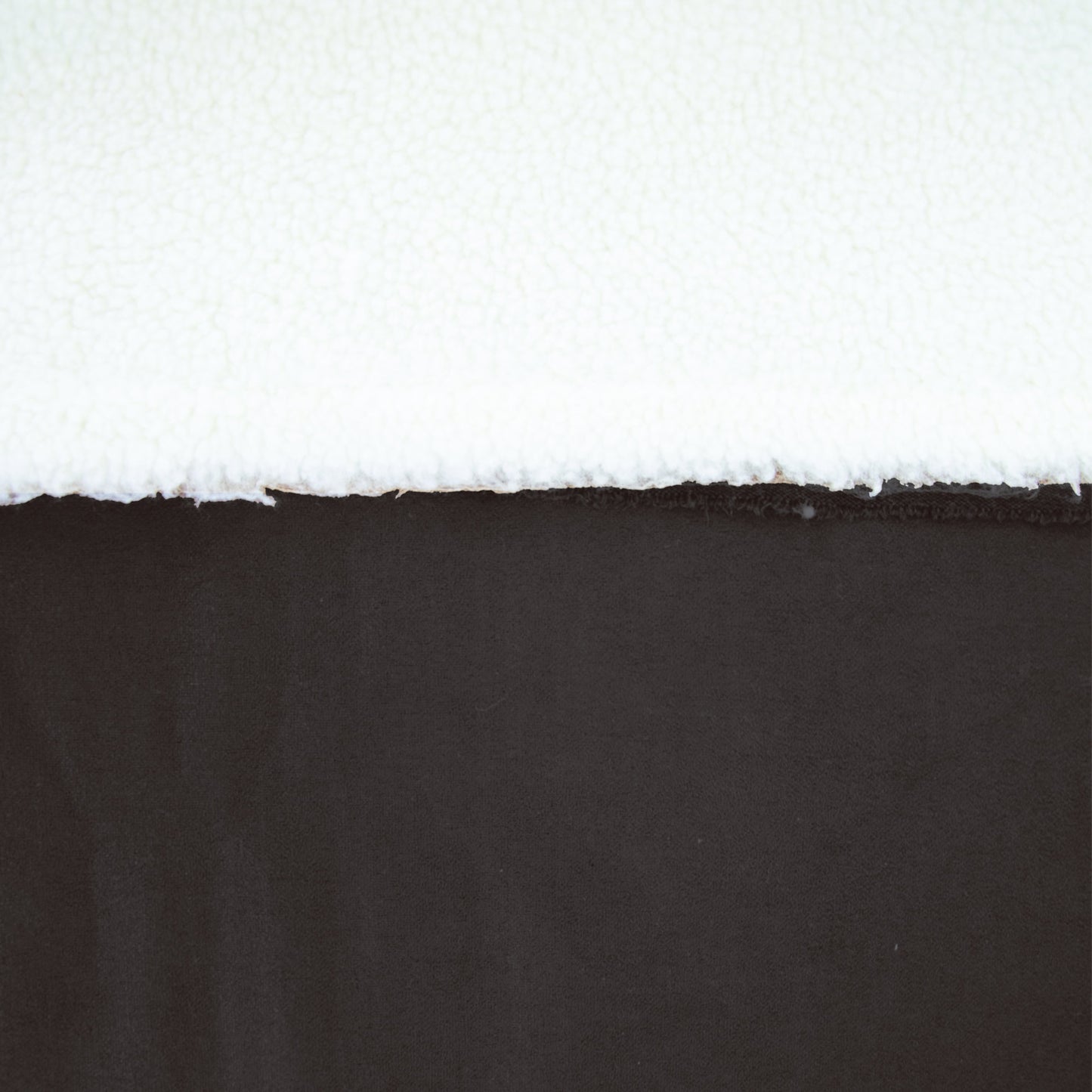 Zwarte suede stof met witte sherpa fleece achterkant.