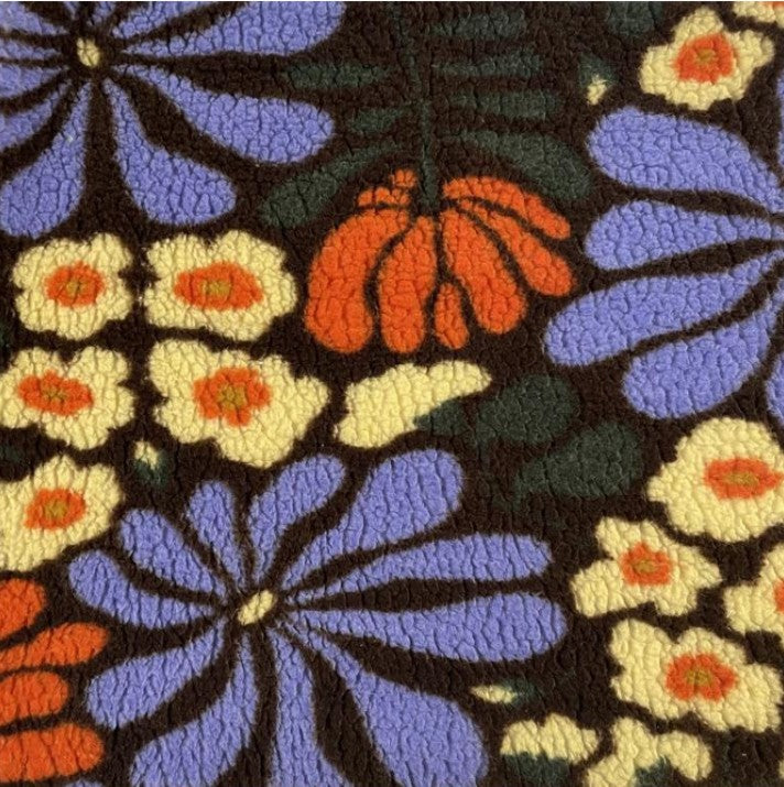 Teddy stof met retro bloemen in kleuren zoals geel oranje groen en lavendel.