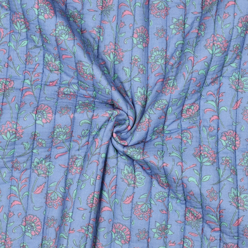 Double gauze met bloemen die gewatteerd en doorgestikt is en aan twee kanten draagbaar in de kleuren blauw en groen.