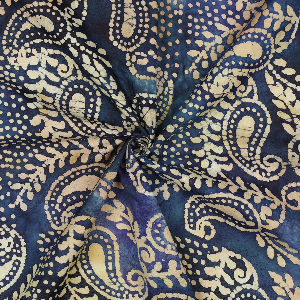 Blauwe batik katoenen stof met beige tekeningen.