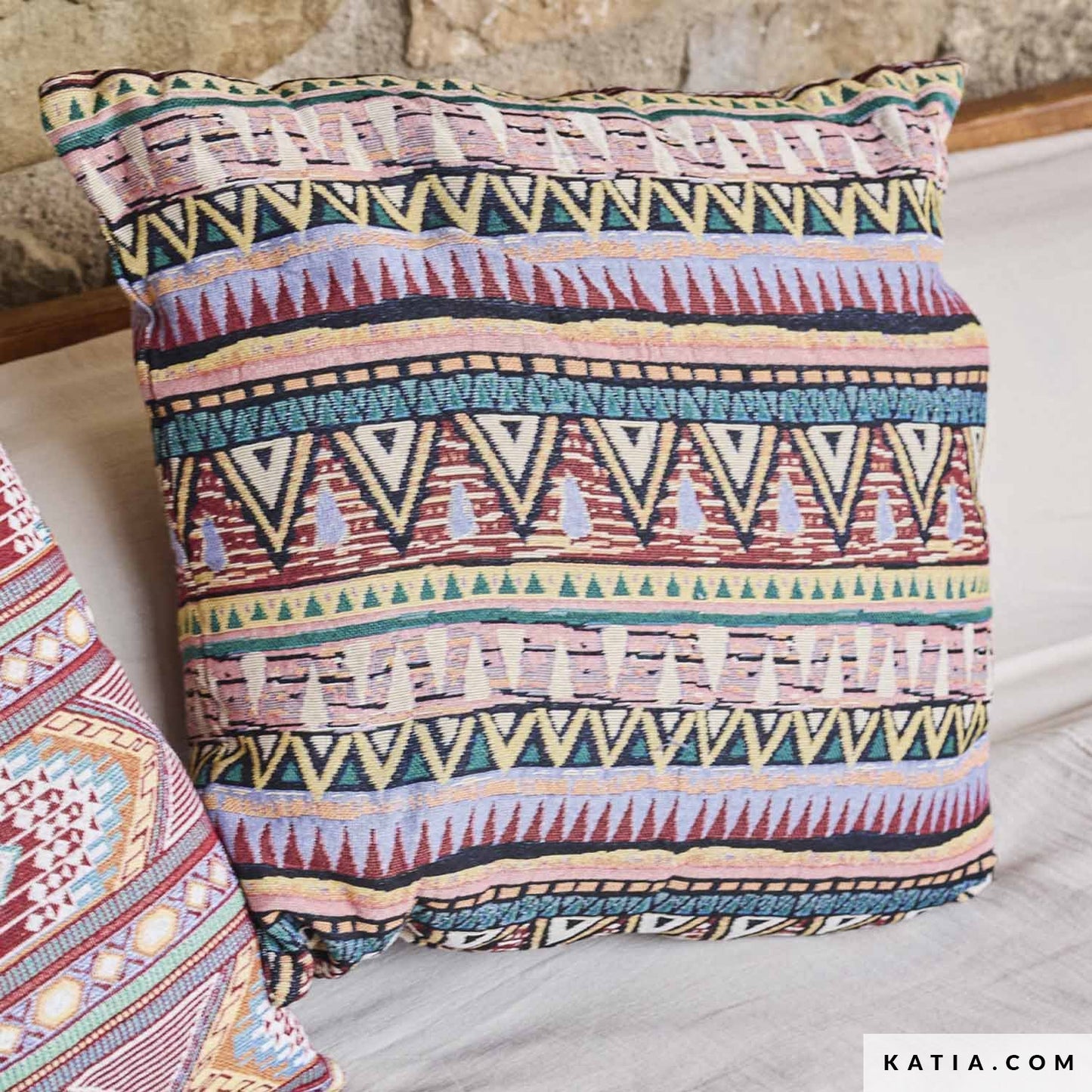 Kussen gemaakt van jacquard stof met etnische figuren in kleurrijke print.