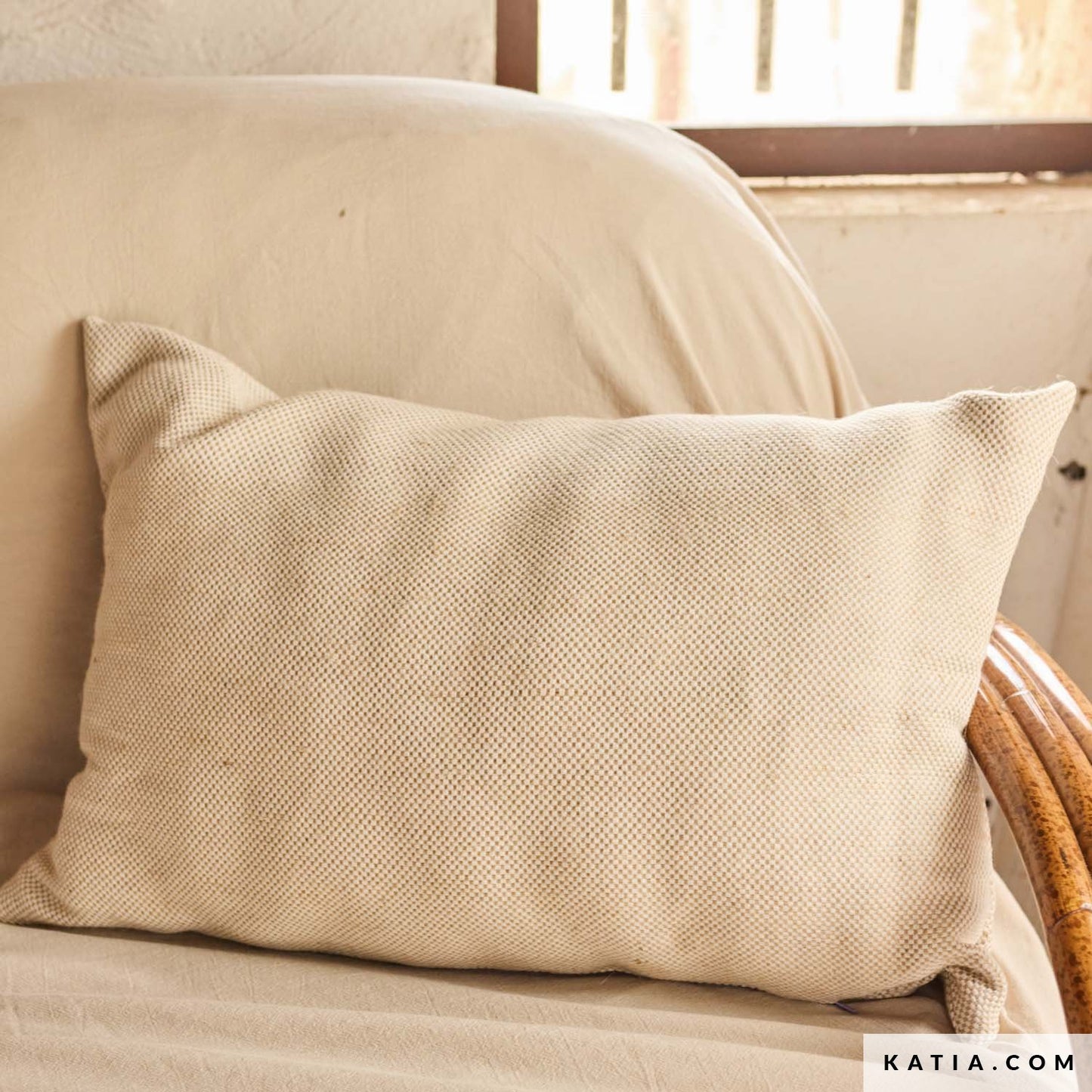Sierkussen gemaakt van dikke katoenen linnen stof in natuurtinten van beige en lichtbruin met klein ruitje.