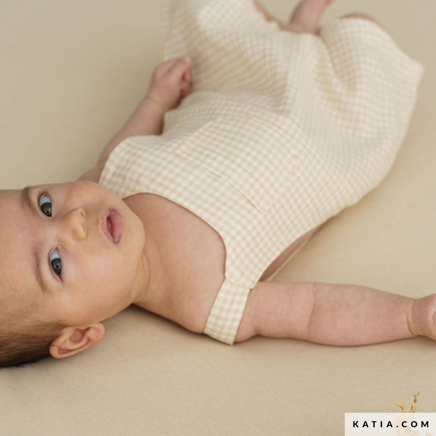 Babypakje gemaakt van biologisch katoenen double gauze in de kleur ecru met beige blokjes.