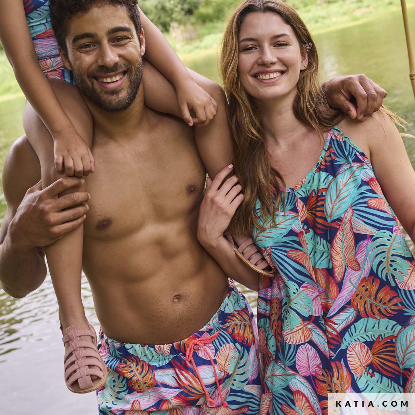 Jurk gemaakt van blauwe viscose met grote tropisch bladeren in kleuren oranje, turquoise en roze.
